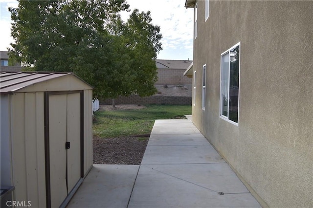 exterior space with an outbuilding, a patio, and a storage unit