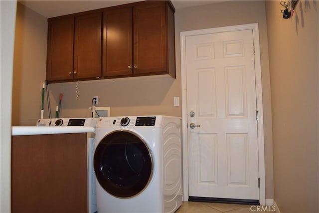 laundry area with cabinet space, separate washer and dryer, and light tile patterned flooring