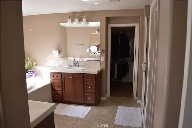 bathroom featuring tile patterned flooring, a walk in closet, vanity, a shower stall, and a bath