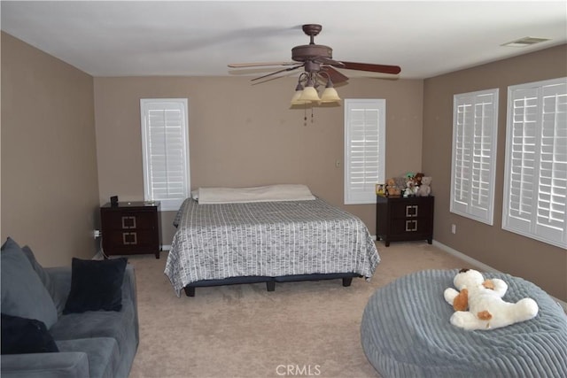 bedroom with baseboards, visible vents, ceiling fan, and carpet flooring