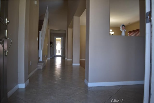 hall with baseboards and tile patterned floors