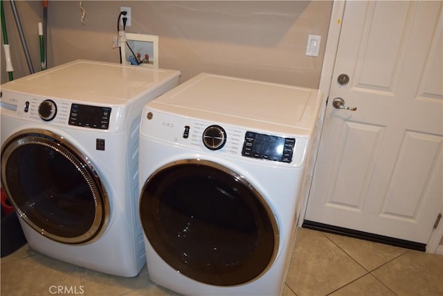 laundry room featuring laundry area, washer and clothes dryer, and light tile patterned flooring