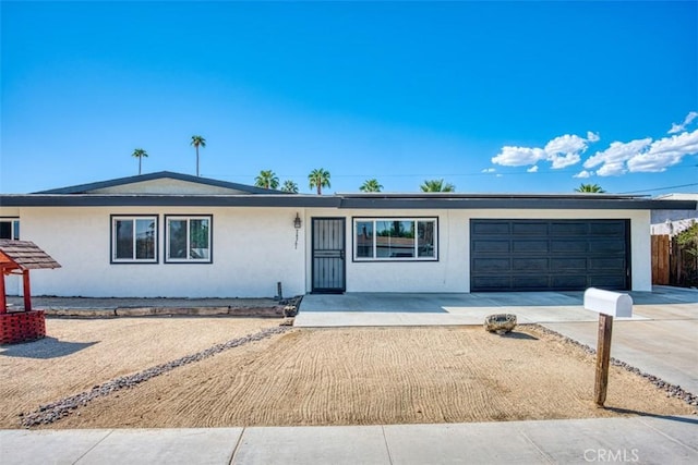 single story home featuring a garage, driveway, and stucco siding