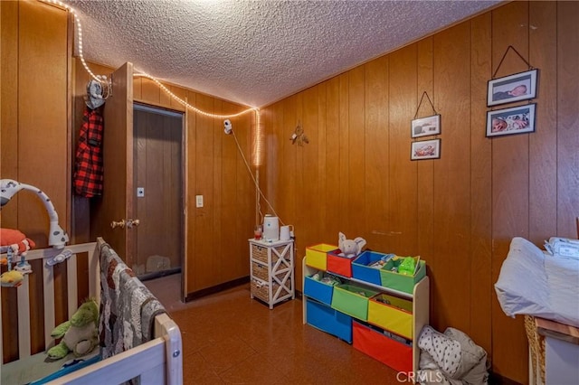 bedroom with a textured ceiling, wood walls, and tile patterned floors