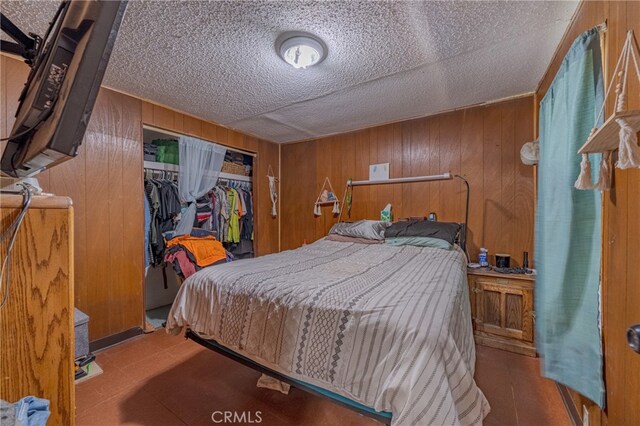 bedroom featuring wooden walls and a closet