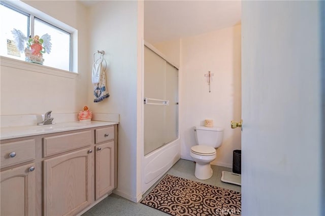 bathroom with enclosed tub / shower combo, toilet, vanity, and baseboards