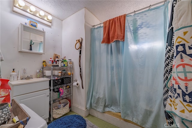 bathroom featuring a textured ceiling, toilet, vanity, and walk in shower