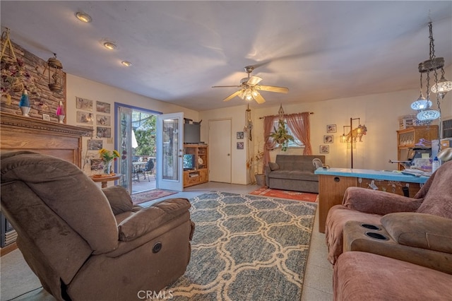 living room with ceiling fan and a stone fireplace