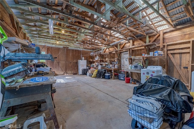 misc room with a workshop area, concrete flooring, and vaulted ceiling