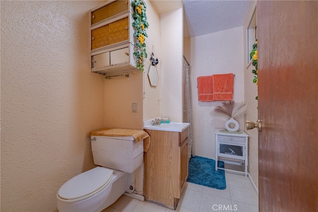 bathroom featuring a textured ceiling, tile patterned flooring, vanity, and toilet