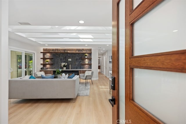 living room featuring beam ceiling and light hardwood / wood-style flooring