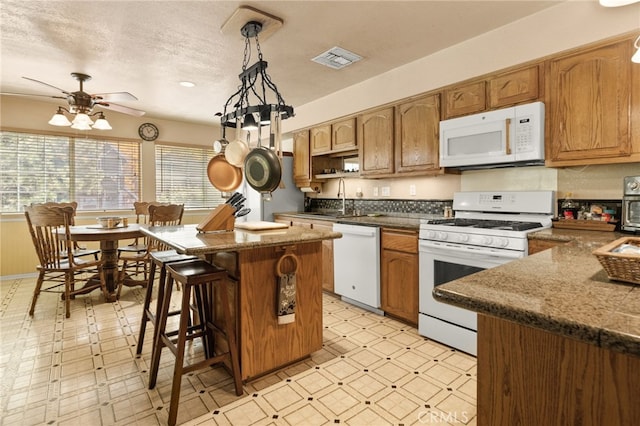 kitchen featuring white appliances, a textured ceiling, ceiling fan, sink, and pendant lighting