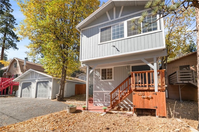 view of front facade featuring covered porch, a garage, and an outbuilding