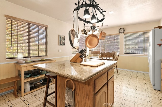 kitchen featuring wood walls, a healthy amount of sunlight, and white refrigerator