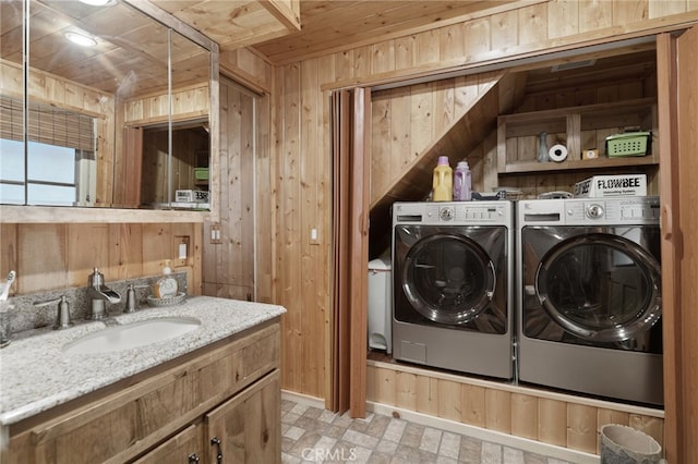 clothes washing area featuring separate washer and dryer, sink, wooden walls, and wooden ceiling