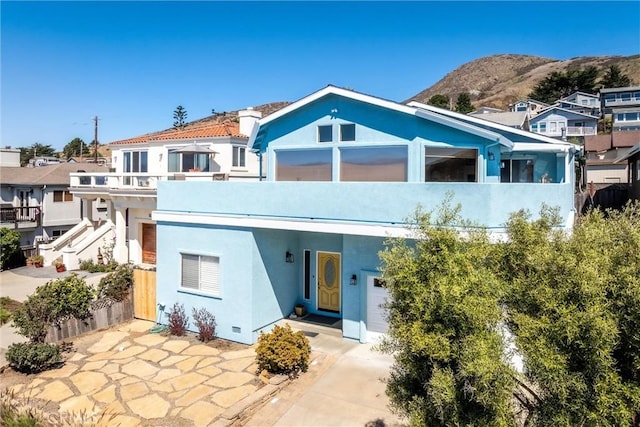 rear view of property with a mountain view and a balcony