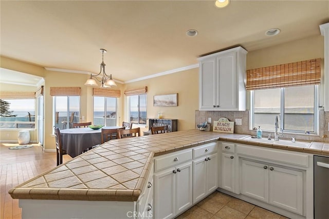 kitchen with tile counters, decorative light fixtures, and kitchen peninsula