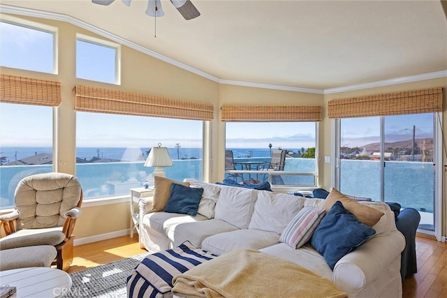 sunroom / solarium featuring ceiling fan and a water view