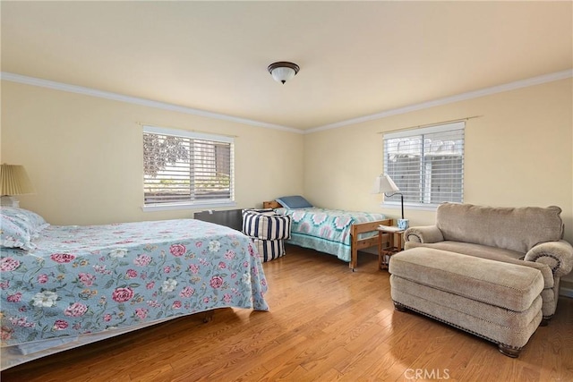 bedroom featuring light hardwood / wood-style flooring and crown molding