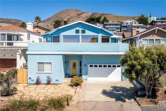 view of front facade featuring a mountain view, a balcony, and a garage