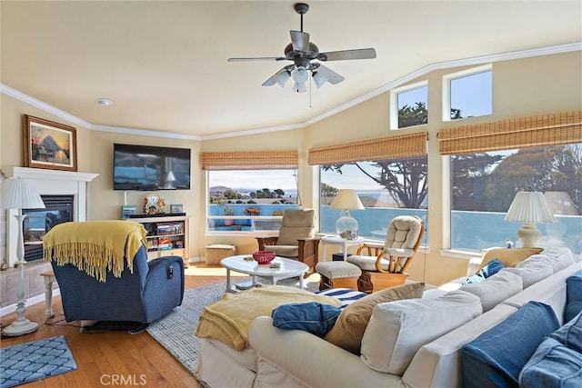 living room with ceiling fan, wood-type flooring, ornamental molding, and lofted ceiling