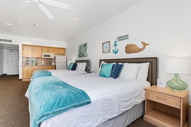 carpeted bedroom featuring ceiling fan and white fridge