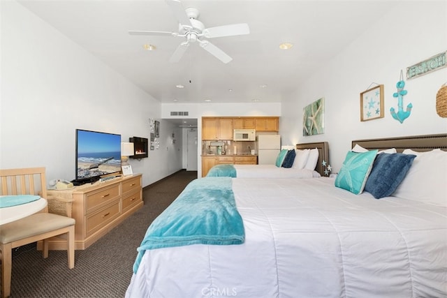 carpeted bedroom featuring white refrigerator and ceiling fan