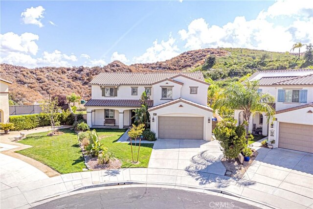 mediterranean / spanish-style home with a mountain view and a front lawn