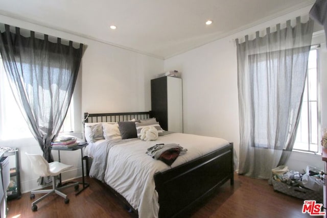 bedroom featuring ornamental molding and dark wood-type flooring