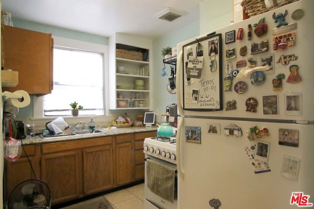 kitchen with sink, light tile patterned flooring, and white appliances