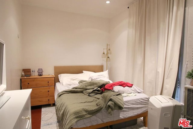 bedroom with ornamental molding and hardwood / wood-style flooring