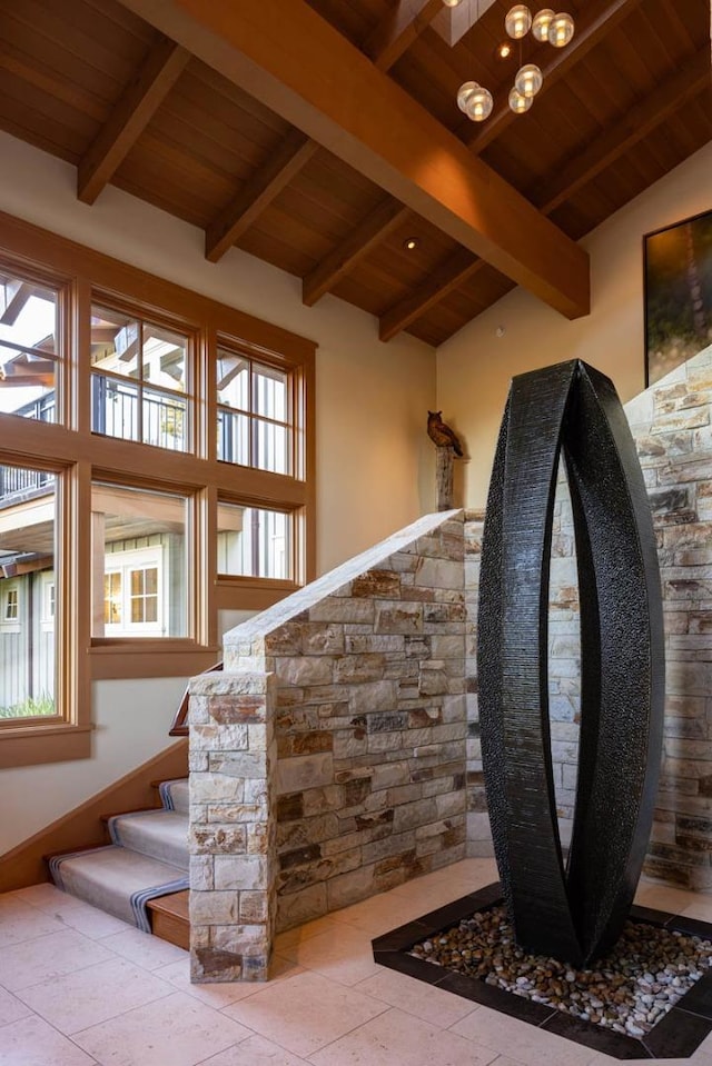 stairway featuring plenty of natural light, lofted ceiling with beams, and wooden ceiling