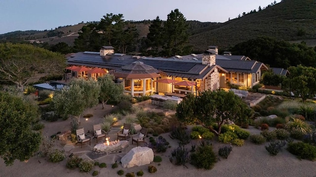 rear view of property with a patio area and a fire pit