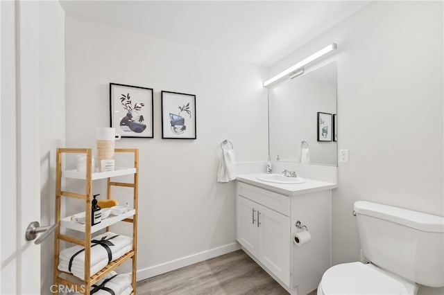 bathroom featuring hardwood / wood-style flooring, vanity, and toilet