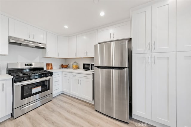 kitchen with light hardwood / wood-style flooring, appliances with stainless steel finishes, and white cabinetry