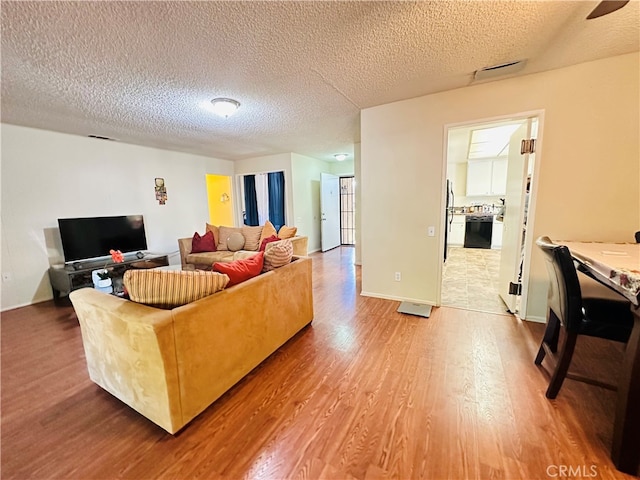 living room with wood-type flooring and a textured ceiling