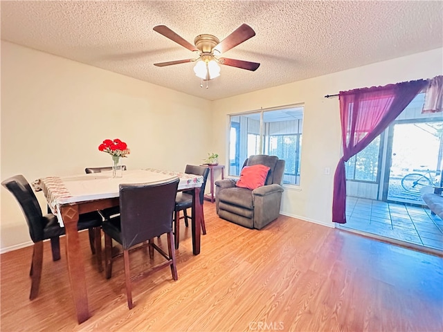 dining room with a textured ceiling, light hardwood / wood-style floors, and ceiling fan