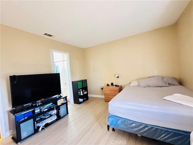 27358 Comwell St, Menifee, CA 92586 - bedroom with light wood-style floors, baseboards, a textured ceiling, and visible vents