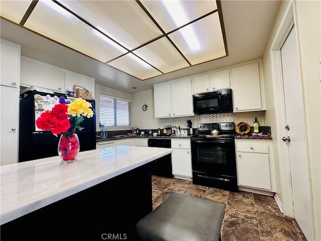 kitchen featuring white cabinetry, tasteful backsplash, and black appliances