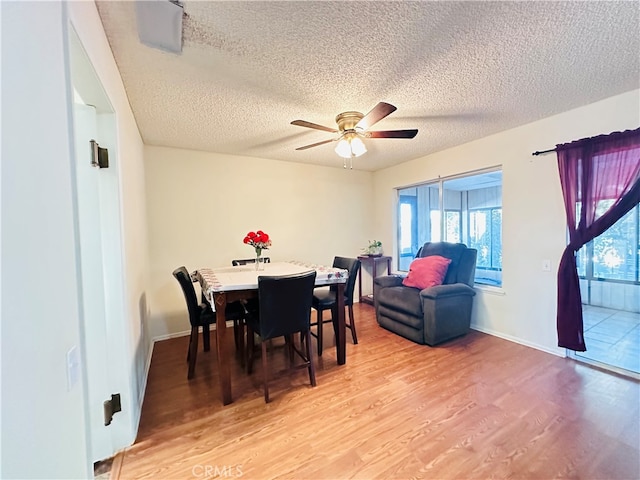 dining room with a textured ceiling, hardwood / wood-style flooring, and ceiling fan