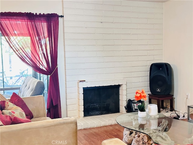 living room featuring hardwood / wood-style floors and a brick fireplace