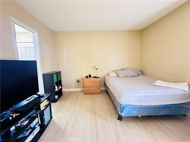 bedroom featuring light hardwood / wood-style flooring and a textured ceiling