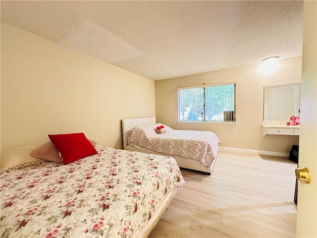 bedroom with wood-type flooring and a textured ceiling