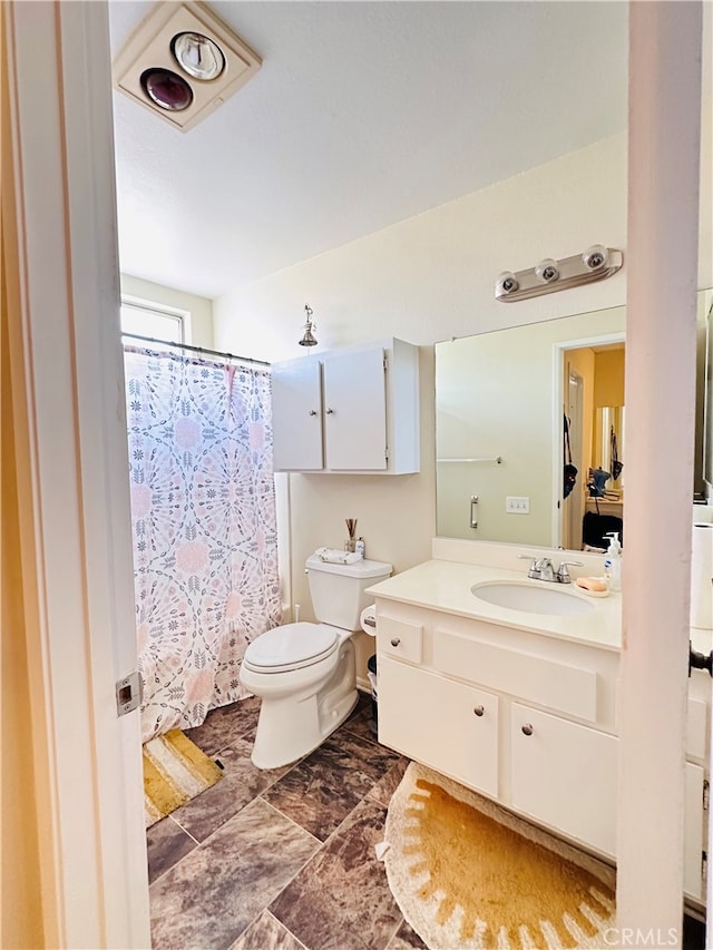 bathroom featuring toilet, curtained shower, and vanity