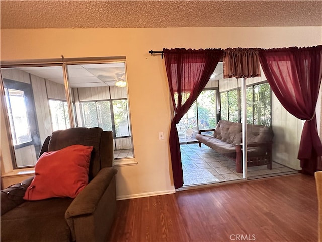 doorway with a textured ceiling, wood-type flooring, and ceiling fan