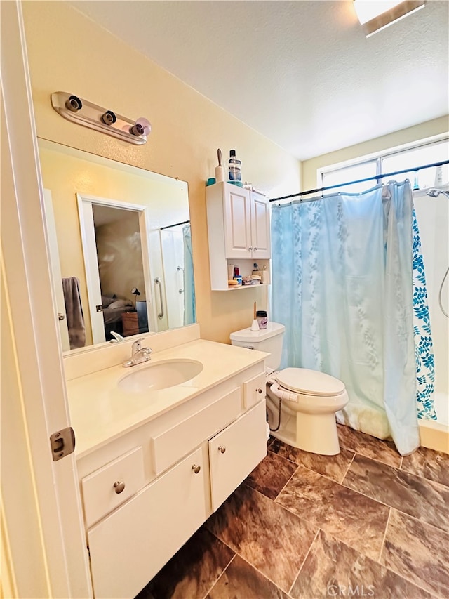 bathroom featuring vanity, curtained shower, and toilet