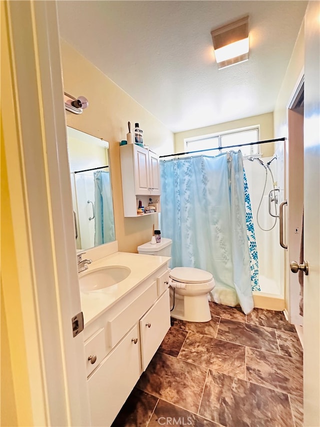 bathroom with vanity, toilet, and curtained shower