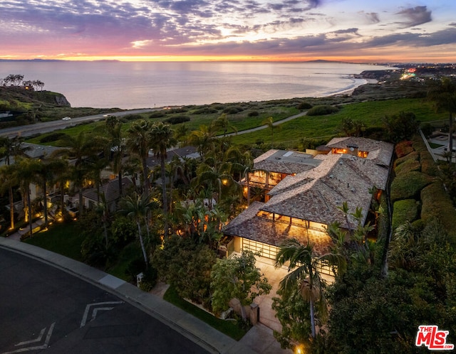 aerial view at dusk featuring a water view