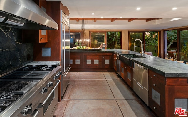 kitchen with tile patterned flooring, sink, decorative backsplash, premium appliances, and exhaust hood