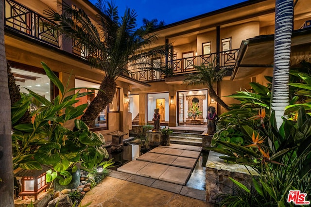 exterior entry at twilight with a balcony